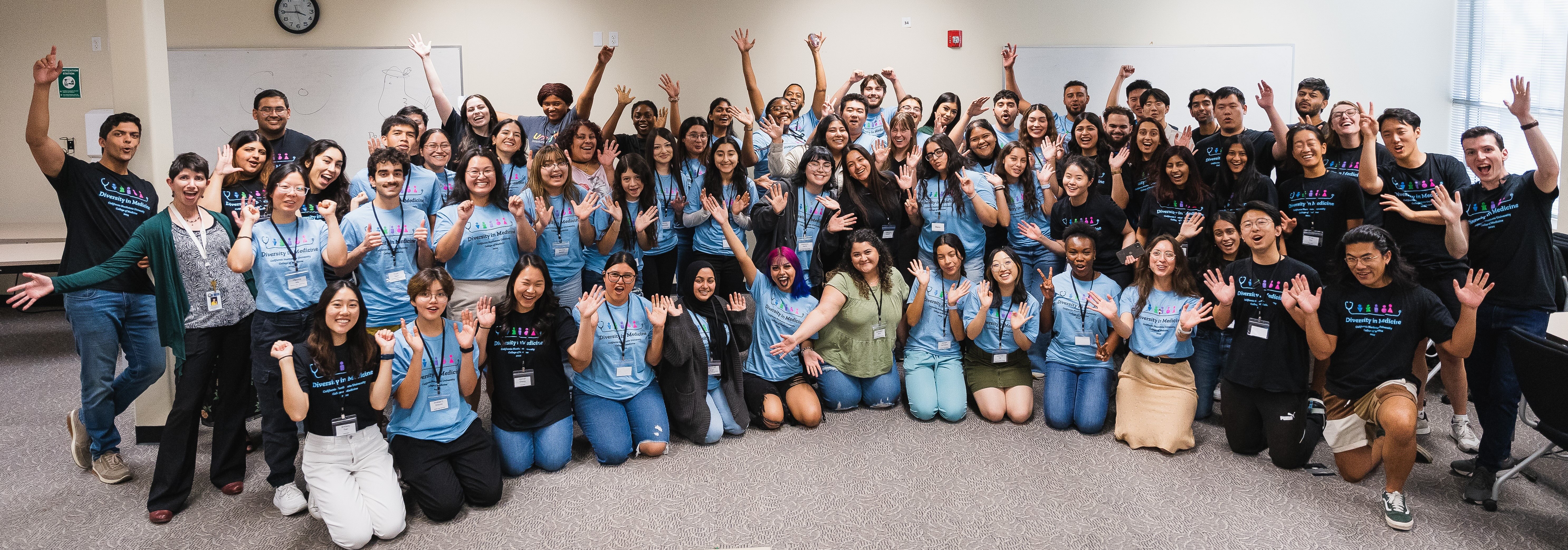 Large group of students that attend California Northstate University College of Medicine gathered, raising their hands and cheering.