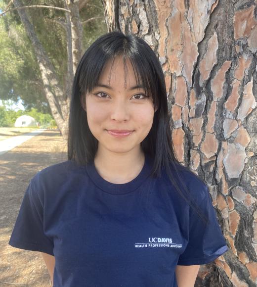 A photo of Stephanie smiling at the camera wearing a blue HPA t-shirt.