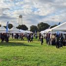 Students visiting many different tents out on a field at an event.