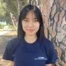 A photo of Stephanie smiling at the camera wearing a blue HPA t-shirt.